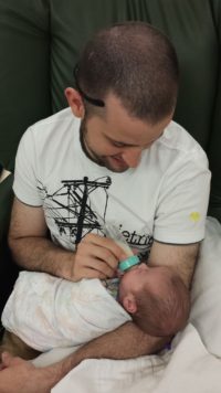 dad feeding NICU baby breastfeeding hand to hold prematurity preemie