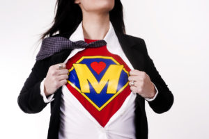 Super mom, NICU, advocate, advocating, Woman wears a superhero style t-shirt under her business suit